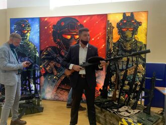 Мужчина демонстрирует пулемет с глушителем LASERWAR.